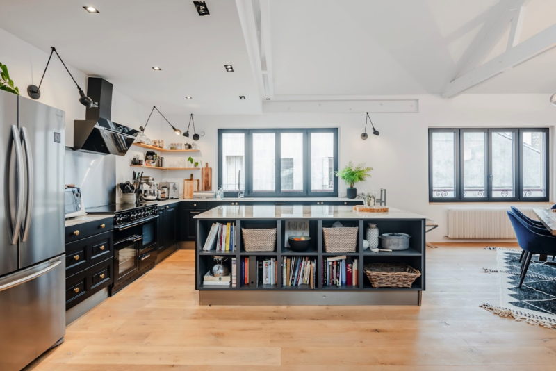 Open-plan chef's kitchen with marble island and black cabinetry — contemporary loft for film shoot and culinary production near Paris | Easy Spaces