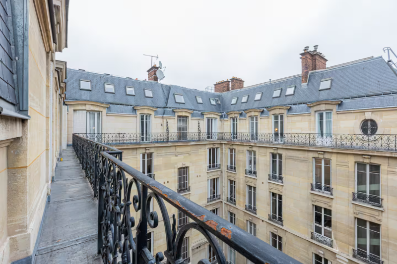 rent an apartment with a balcony offering a panoramic view of Parisian rooftops during a photoshoot in France